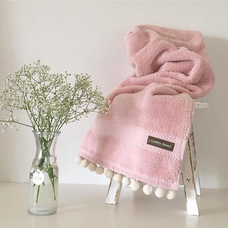 Towel with pompoms